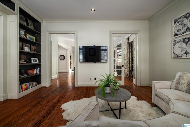 living room featuring crown molding, built in features, wood finished floors, and baseboards