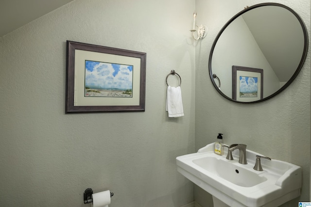 bathroom featuring a textured wall and a sink