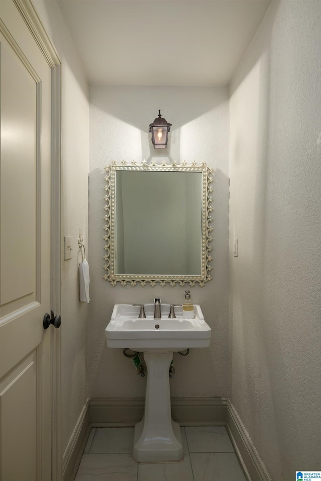 bathroom with marble finish floor and baseboards