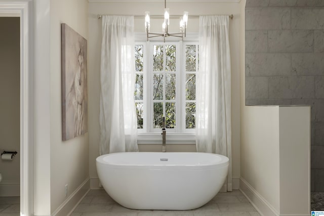 bathroom with a freestanding tub, baseboards, marble finish floor, and a chandelier