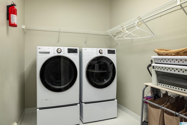 laundry area with light tile patterned flooring, laundry area, baseboards, and separate washer and dryer