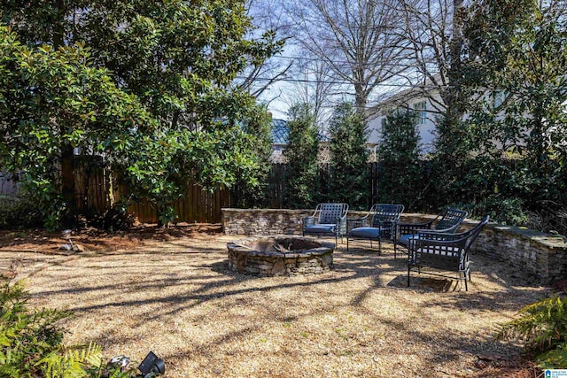 view of yard with fence and an outdoor fire pit