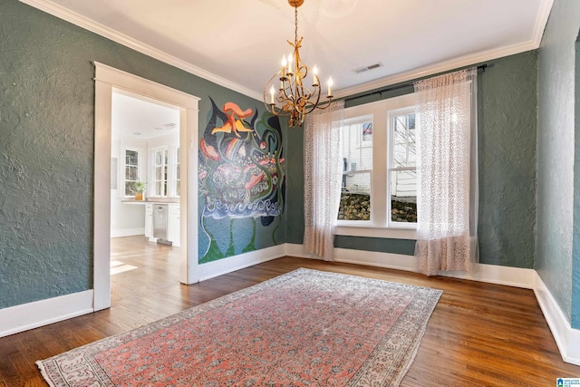 unfurnished dining area featuring a chandelier, wood finished floors, crown molding, and a textured wall