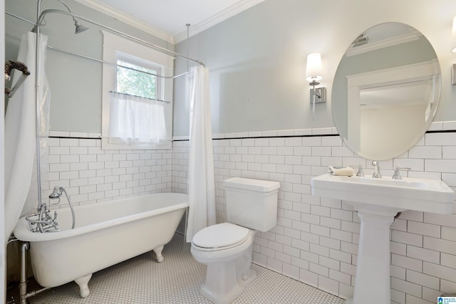 bathroom with toilet, ornamental molding, tile patterned floors, a soaking tub, and tile walls