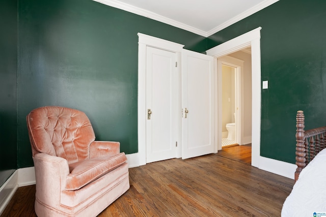 living area with crown molding, baseboards, and wood finished floors