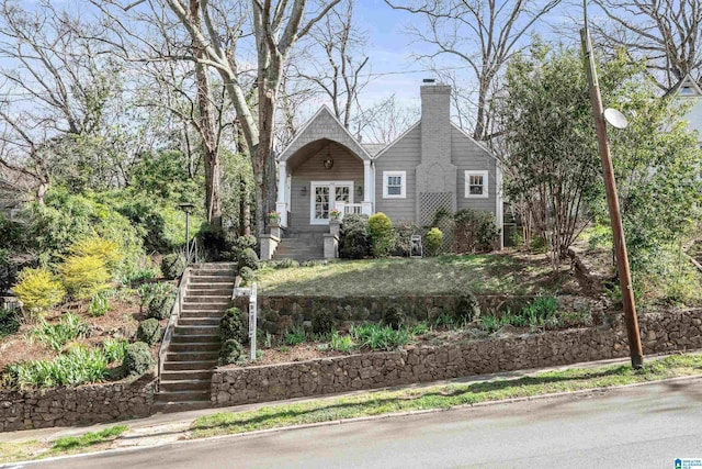 view of front of home featuring stairs and a chimney