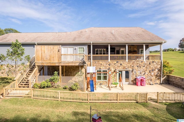 back of property with a lawn, a patio, fence, stairway, and roof with shingles