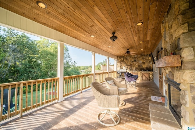 wooden deck with grilling area and a ceiling fan