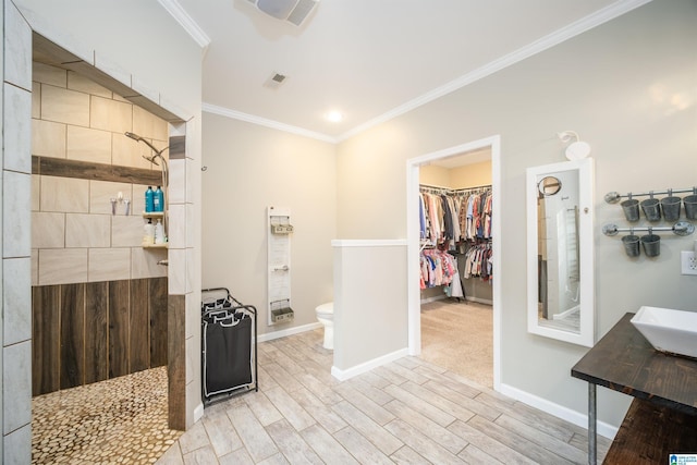 full bath featuring toilet, wood finished floors, crown molding, and a walk in shower