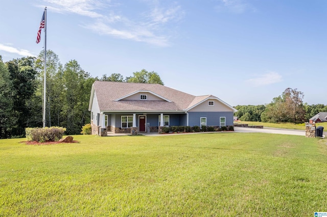 view of front of home with covered porch, a shingled roof, and a front yard