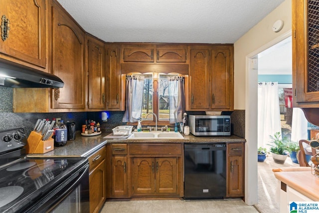 kitchen with brown cabinetry, a sink, black appliances, dark countertops, and tasteful backsplash