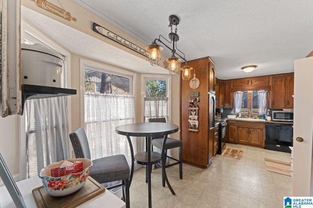 kitchen with brown cabinets, black appliances, a sink, decorative light fixtures, and a textured ceiling