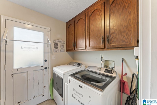 clothes washing area with cabinet space, a textured ceiling, and washing machine and dryer