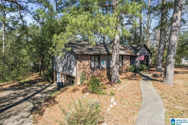 view of front of property with brick siding, an attached garage, driveway, and roof with shingles