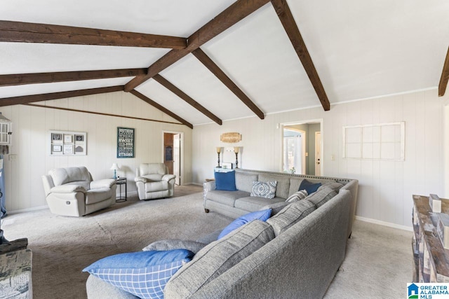 living area with baseboards, vaulted ceiling with beams, and carpet flooring