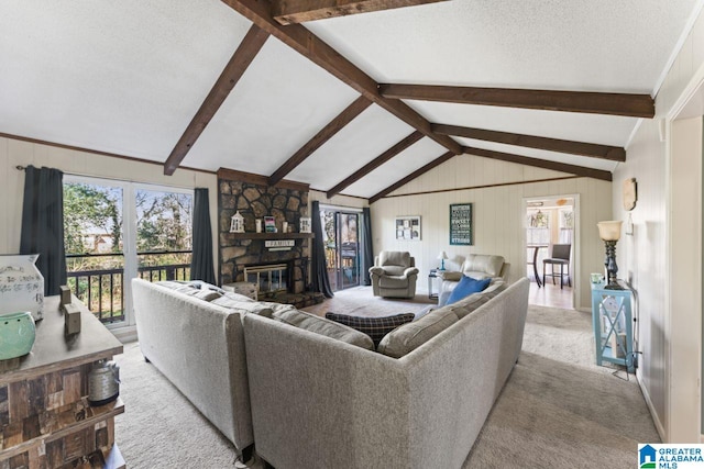 carpeted living room with plenty of natural light, a fireplace, vaulted ceiling with beams, and a textured ceiling