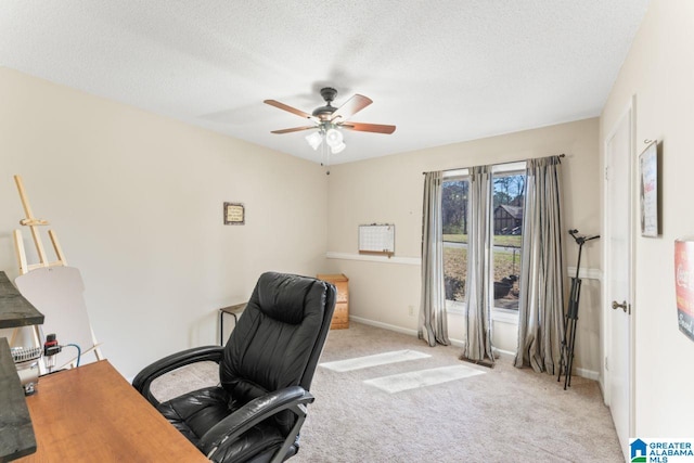 carpeted office space featuring baseboards, a textured ceiling, and a ceiling fan