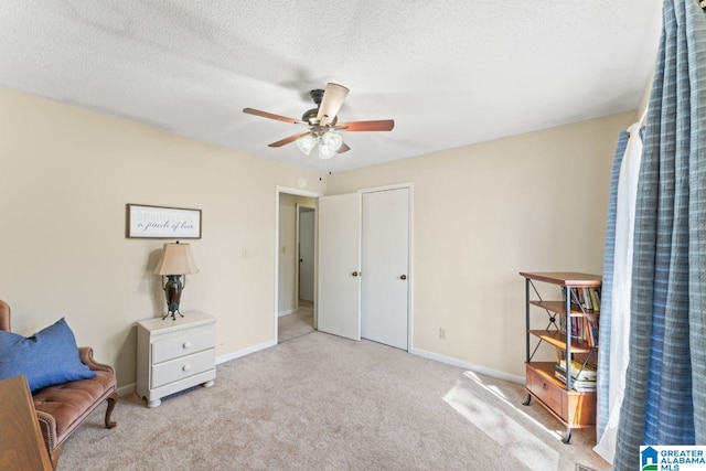 sitting room with baseboards, carpet floors, and a textured ceiling