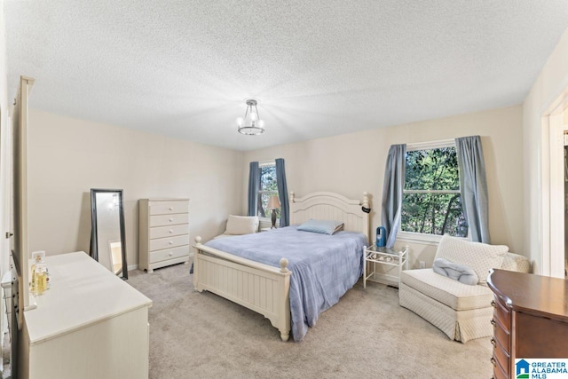 bedroom with light carpet, a notable chandelier, and a textured ceiling