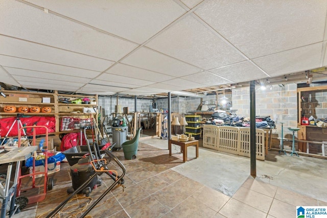 finished basement with a drop ceiling and concrete block wall