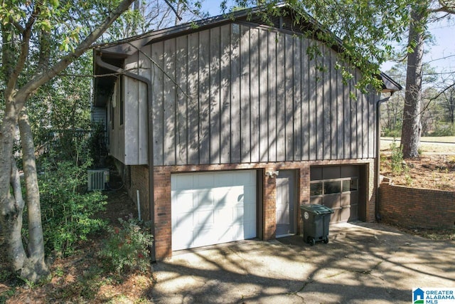 garage with central AC unit and driveway