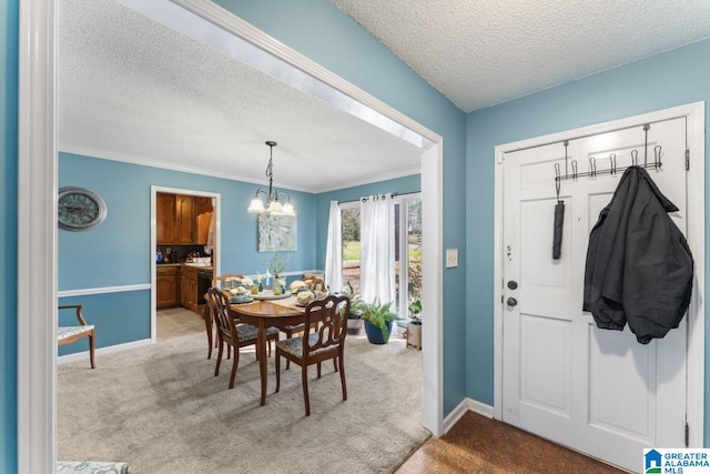 carpeted dining room featuring an inviting chandelier, crown molding, baseboards, and a textured ceiling