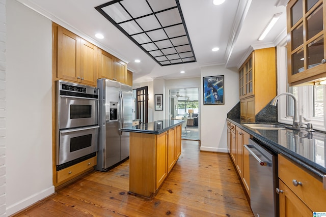 kitchen featuring a sink, a kitchen island, wood-type flooring, and stainless steel appliances