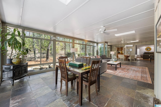 sunroom / solarium featuring a wealth of natural light, ceiling fan, and a skylight