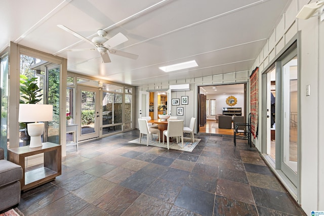 sunroom / solarium with french doors, an AC wall unit, and a ceiling fan