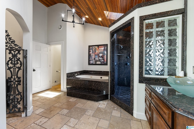 bathroom with a garden tub, wood ceiling, a walk in shower, and stone tile flooring