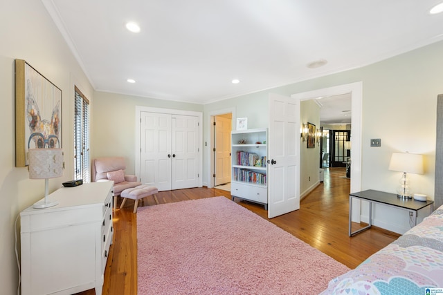 bedroom with crown molding, recessed lighting, wood finished floors, and baseboards