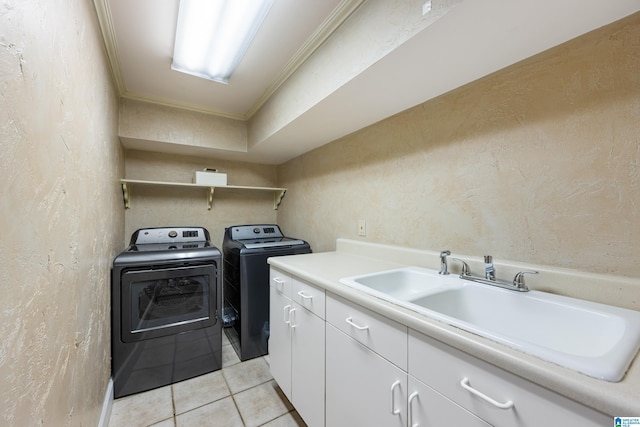 washroom with light tile patterned floors, a textured wall, cabinet space, a sink, and washing machine and dryer