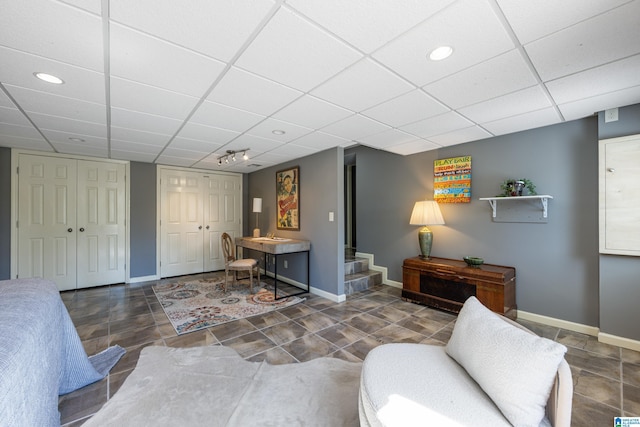 living room featuring recessed lighting, a paneled ceiling, baseboards, and stairway