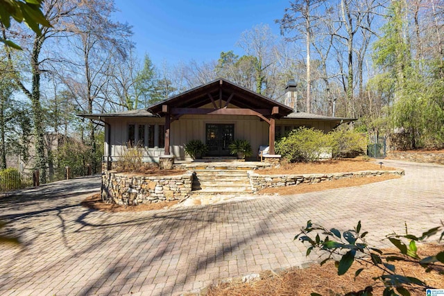 view of front of property featuring decorative driveway, french doors, and board and batten siding