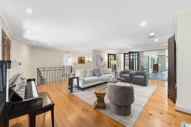 living room featuring recessed lighting, light wood-type flooring, and ornamental molding