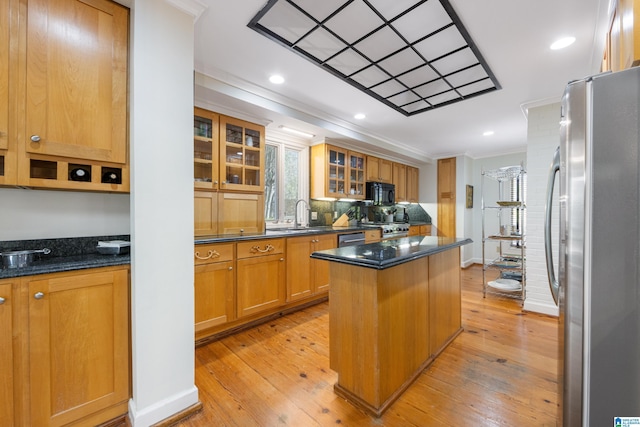 kitchen with a sink, a kitchen island, freestanding refrigerator, black microwave, and crown molding