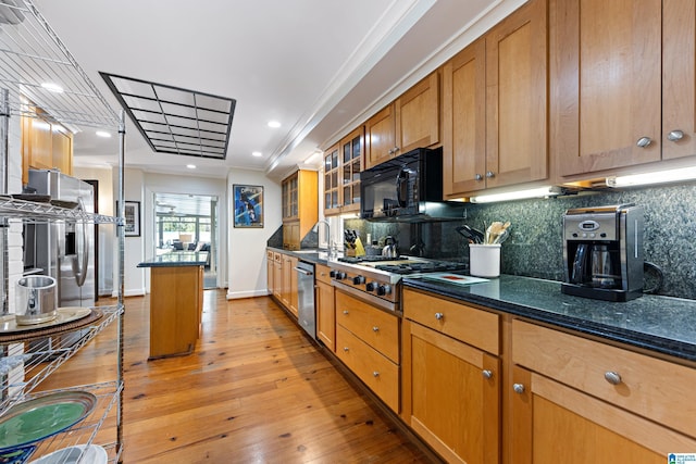 kitchen with tasteful backsplash, a kitchen island, ornamental molding, light wood-style floors, and stainless steel appliances