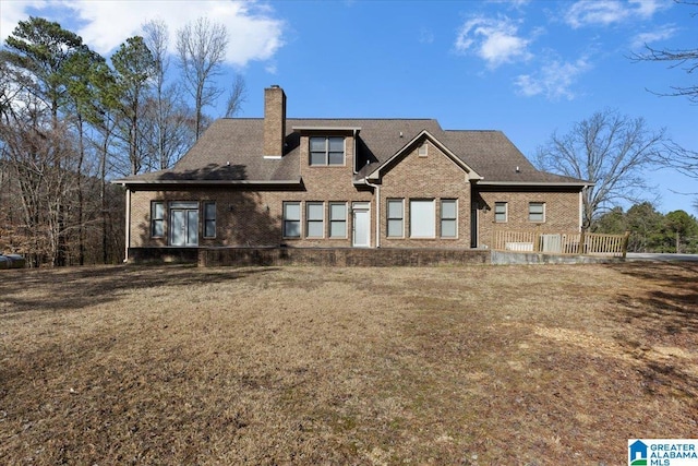 rear view of house featuring brick siding and a chimney