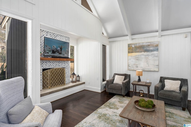 living room featuring lofted ceiling with beams, wood finished floors, and a tile fireplace