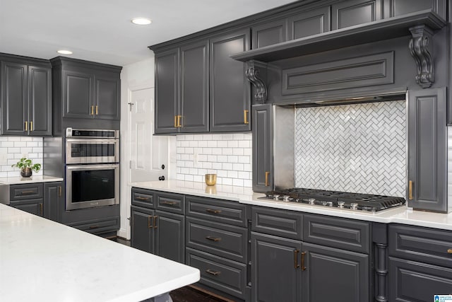 kitchen with decorative backsplash, light countertops, recessed lighting, and appliances with stainless steel finishes