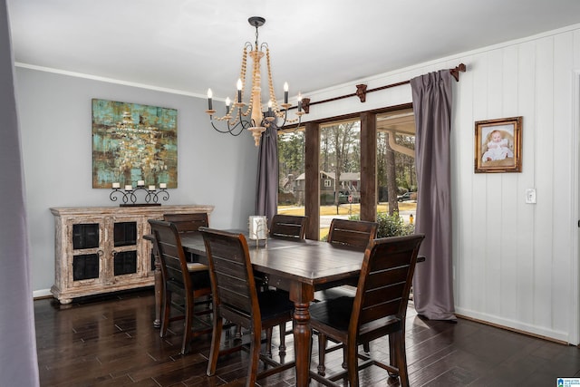 dining area with dark wood-type flooring, a chandelier, and ornamental molding