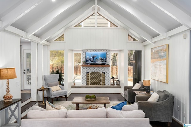 living room with a tiled fireplace, beam ceiling, wood finished floors, and high vaulted ceiling