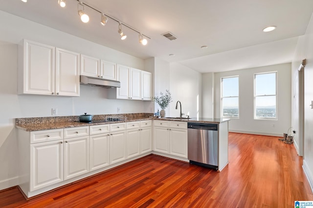 kitchen with visible vents, a peninsula, a sink, under cabinet range hood, and dishwasher