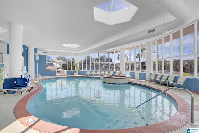 view of swimming pool featuring glass enclosure, a pool with connected hot tub, and a patio area