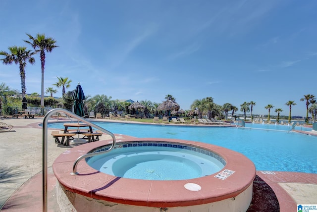 community pool featuring a patio area and a hot tub