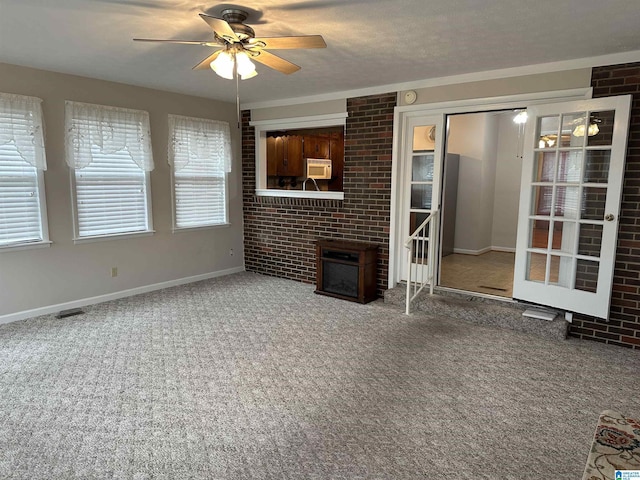 unfurnished living room featuring visible vents, baseboards, carpet flooring, a textured ceiling, and a ceiling fan