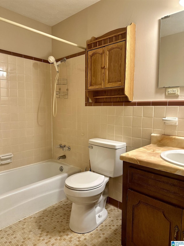 full bathroom featuring vanity, bathtub / shower combination, tile patterned flooring, tile walls, and toilet