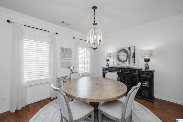 dining room with baseboards, visible vents, dark wood finished floors, crown molding, and a notable chandelier