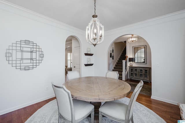 dining area featuring stairs, an inviting chandelier, arched walkways, and dark wood-style flooring