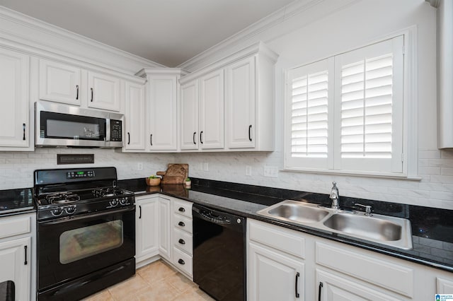 kitchen with dark countertops, decorative backsplash, white cabinets, black appliances, and a sink